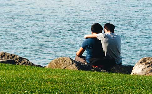 Two people hold hands in a field
