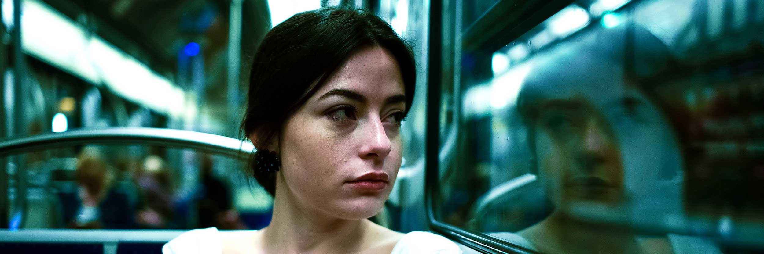 A woman on a train stares out of a window 